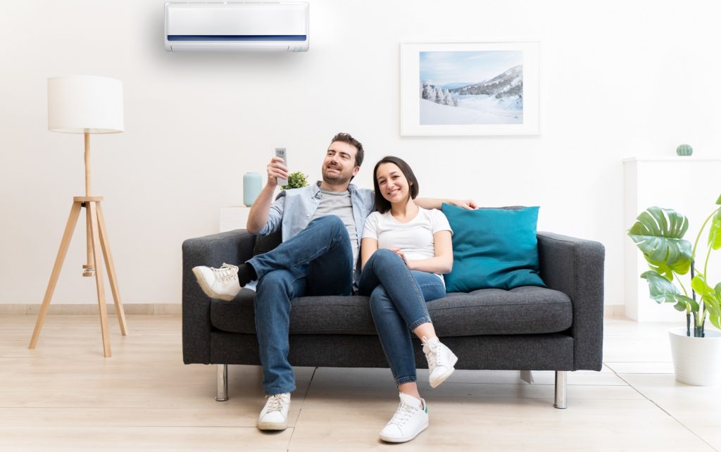 Happy couple cool down using air conditioning at home